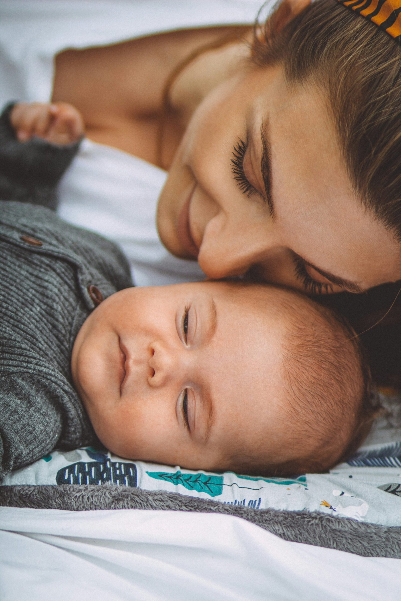 Caregiver settling a newborn in a nursery at night